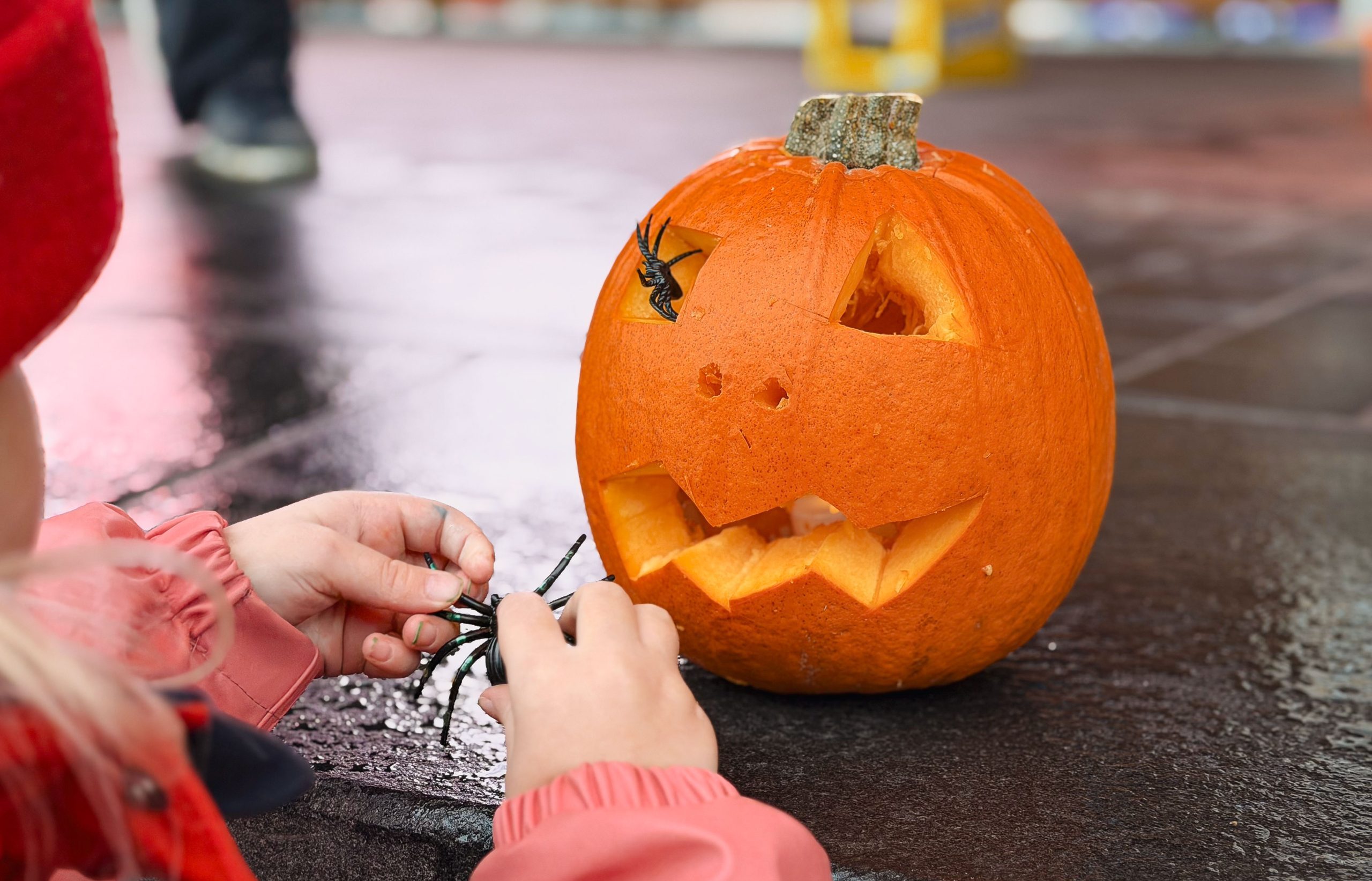 lapsi kaivertaa Halloween kurpitsaa